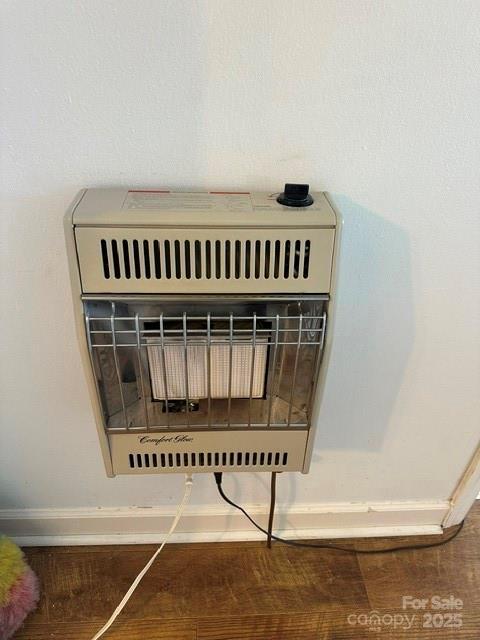 room details featuring heating unit, baseboards, and wood finished floors