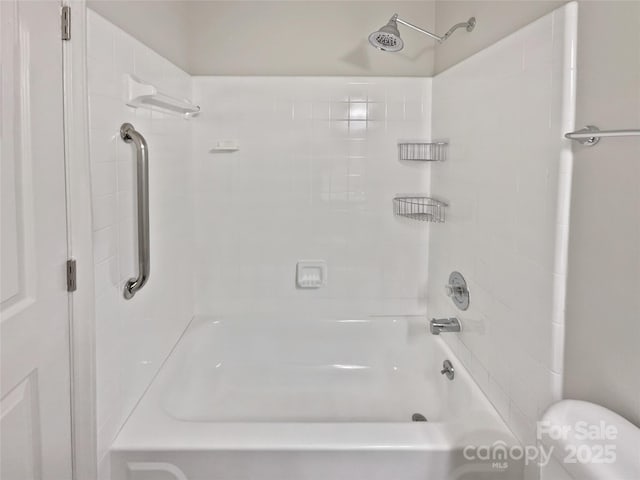 bathroom featuring tub / shower combination and toilet