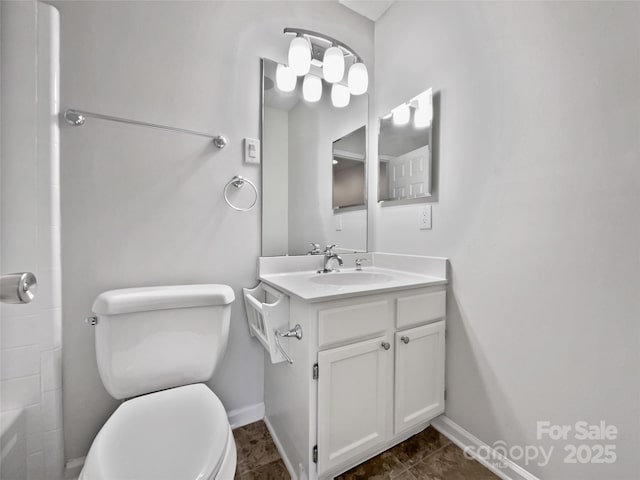 full bath featuring toilet, vanity, and baseboards