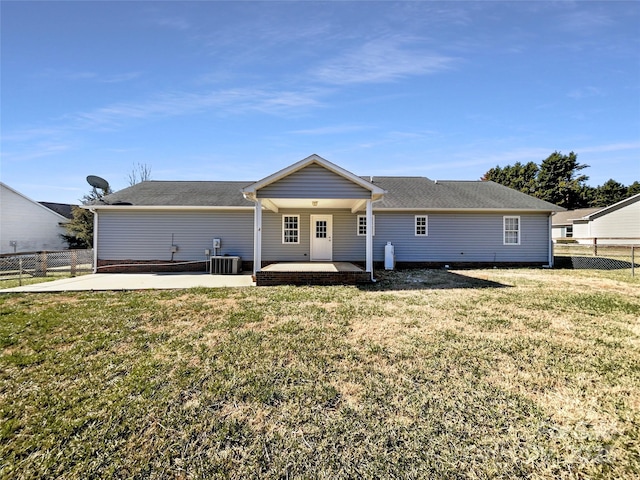 rear view of property with a patio area, a lawn, cooling unit, and fence