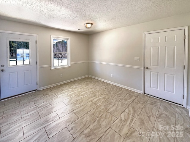 entryway with a textured ceiling and baseboards