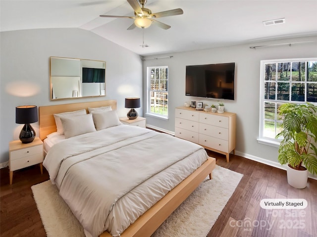 bedroom featuring visible vents, multiple windows, wood finished floors, and vaulted ceiling