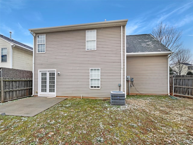 back of property with a patio area, central air condition unit, a fenced backyard, and a lawn