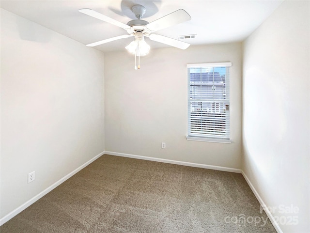 spare room with a ceiling fan, visible vents, carpet, and baseboards