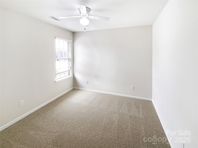 carpeted empty room featuring visible vents, a ceiling fan, and baseboards