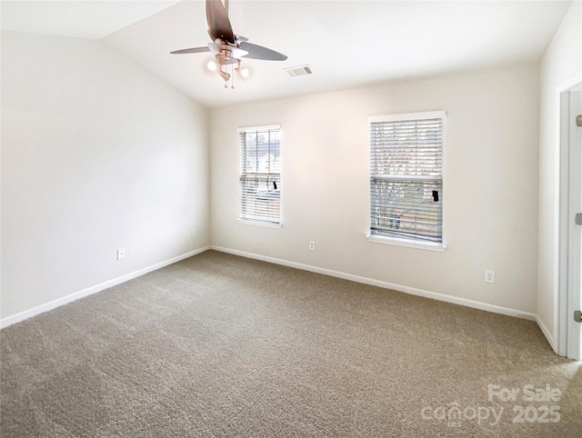 empty room with visible vents, carpet floors, lofted ceiling, and ceiling fan