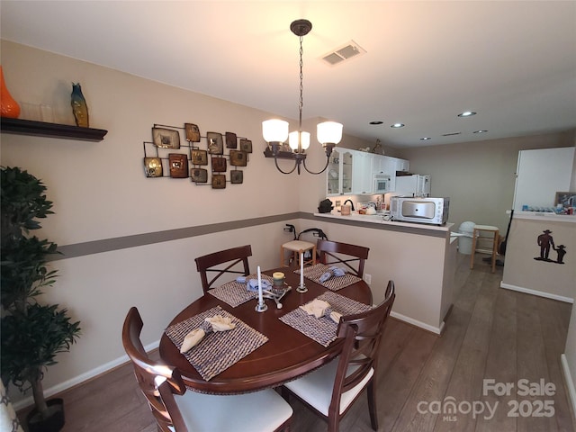 dining room with baseboards, visible vents, recessed lighting, dark wood-style flooring, and a notable chandelier