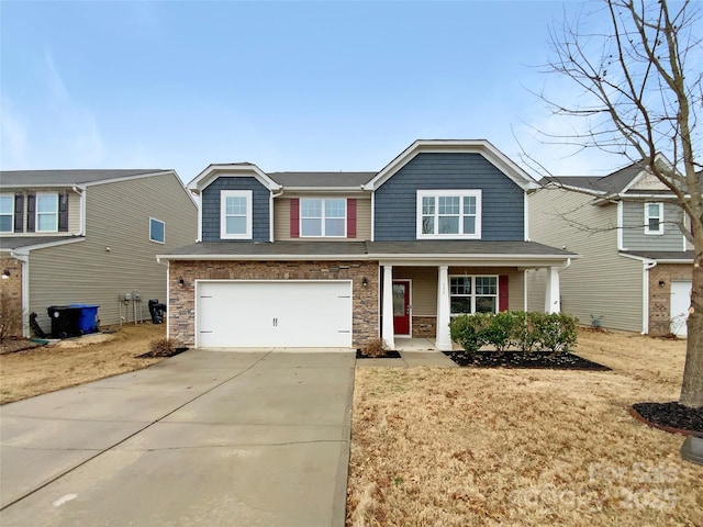 craftsman-style home with a garage, stone siding, covered porch, and driveway