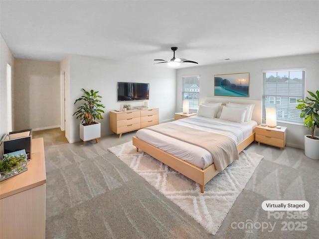 bedroom with multiple windows, light carpet, baseboards, and a ceiling fan