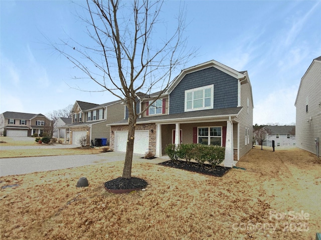 view of front of home with fence, a residential view, covered porch, a garage, and driveway