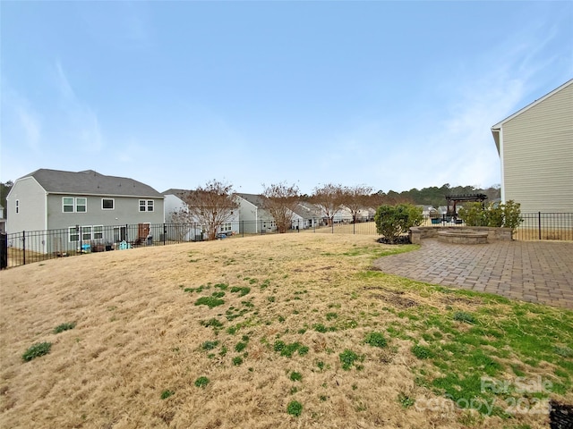 view of yard with a residential view, a fire pit, fence, and a patio area