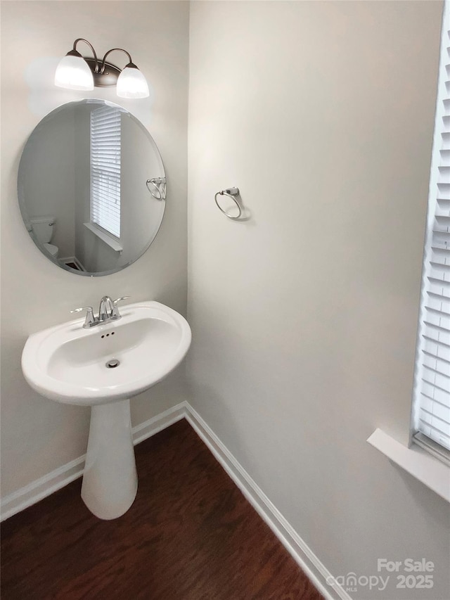 bathroom with baseboards and wood finished floors