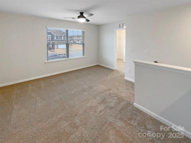 empty room featuring carpet flooring, ceiling fan, and baseboards