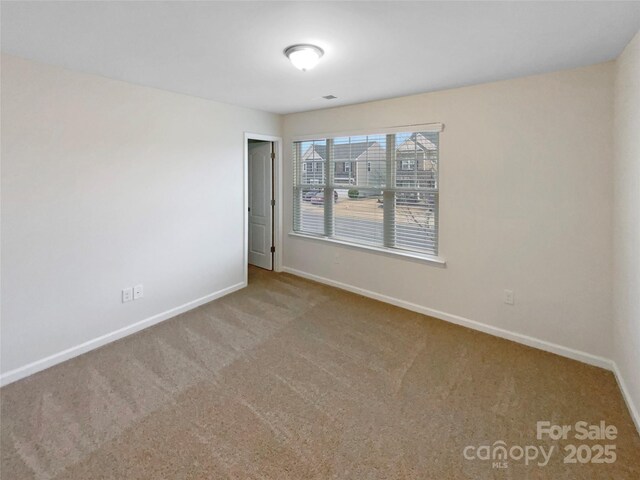 carpeted spare room with baseboards