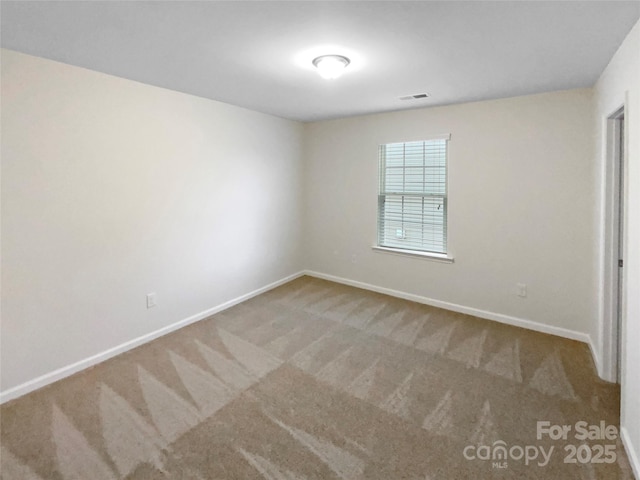 carpeted empty room with visible vents and baseboards