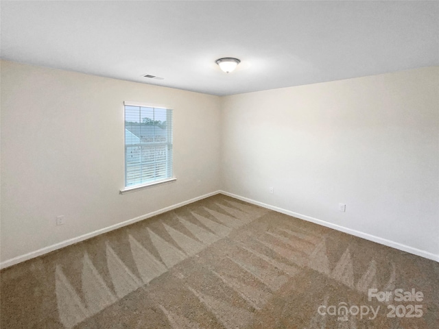 carpeted empty room with visible vents and baseboards