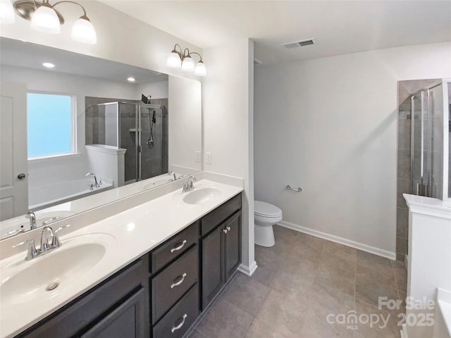 bathroom with visible vents, a stall shower, and a sink