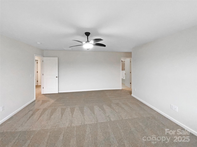 carpeted spare room with baseboards and a ceiling fan