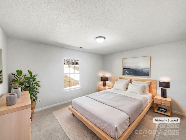 bedroom with baseboards, a textured ceiling, and carpet