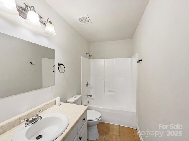 full bath with visible vents, toilet, shower / tub combination, wood finished floors, and vanity