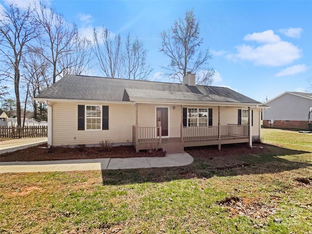 view of front of property featuring roof with shingles, a chimney, a front yard, and fence