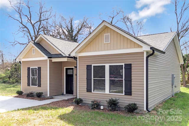 bungalow-style home with a front yard, board and batten siding, and a shingled roof