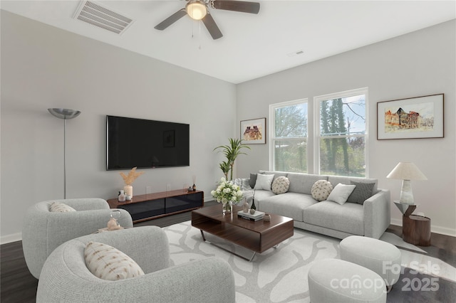 living area featuring ceiling fan, visible vents, baseboards, and wood finished floors