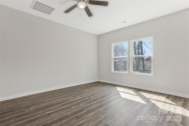 empty room featuring visible vents, baseboards, dark wood-type flooring, and a ceiling fan