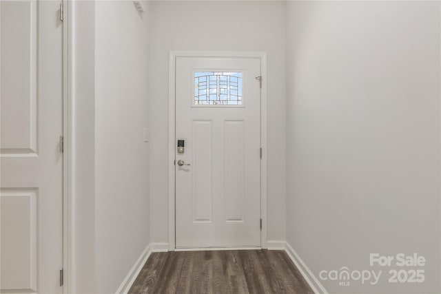 doorway featuring baseboards and dark wood-style flooring