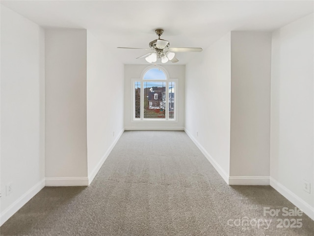 spare room with ceiling fan, baseboards, and carpet floors