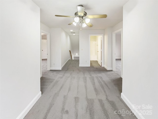 hall with visible vents, baseboards, and carpet floors