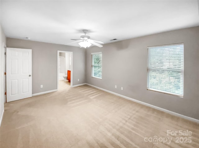 unfurnished bedroom with light carpet, visible vents, ensuite bathroom, and baseboards