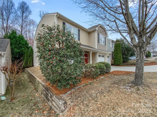 view of property exterior featuring concrete driveway and a garage