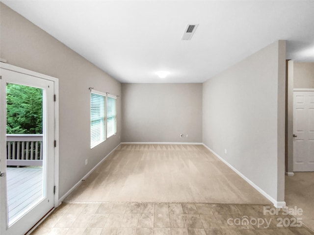 unfurnished room featuring visible vents, baseboards, and light carpet