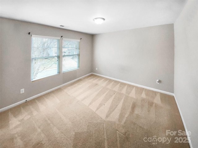 carpeted empty room featuring visible vents and baseboards