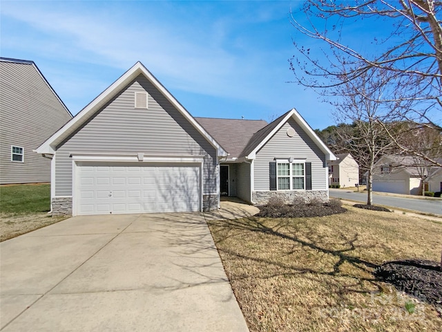 ranch-style home featuring stone siding, a front lawn, concrete driveway, and an attached garage