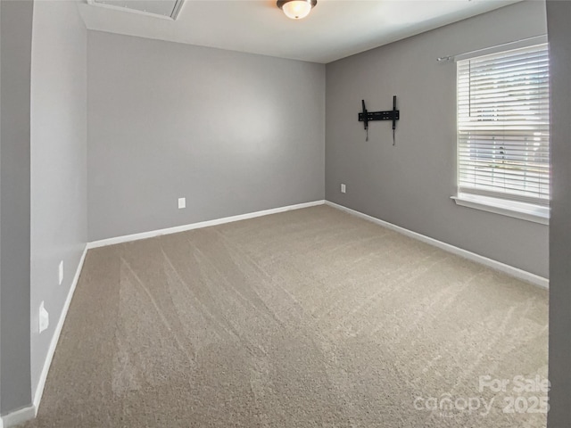 carpeted empty room featuring baseboards