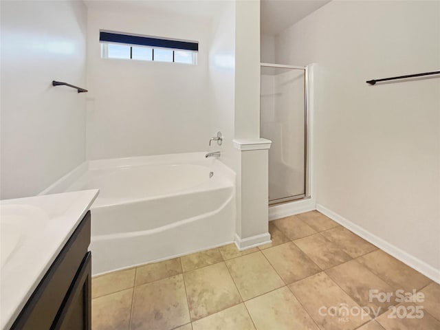 full bathroom featuring tile patterned flooring, baseboards, a stall shower, a bath, and vanity