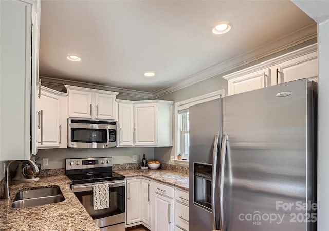 kitchen featuring ornamental molding, recessed lighting, appliances with stainless steel finishes, white cabinets, and a sink