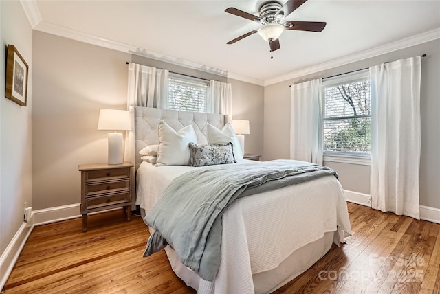 bedroom featuring ceiling fan, baseboards, hardwood / wood-style floors, and crown molding