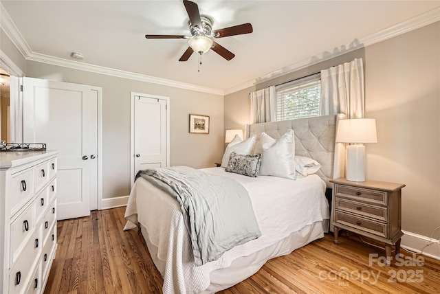 bedroom featuring light wood-type flooring, baseboards, ceiling fan, and crown molding