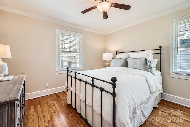 bedroom with crown molding, multiple windows, and wood finished floors