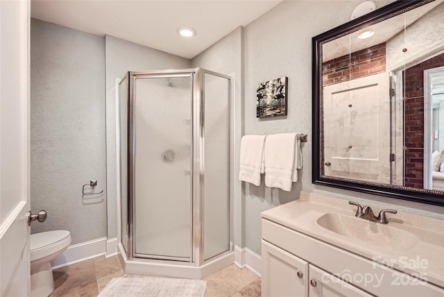 full bathroom featuring vanity, toilet, baseboards, and a stall shower