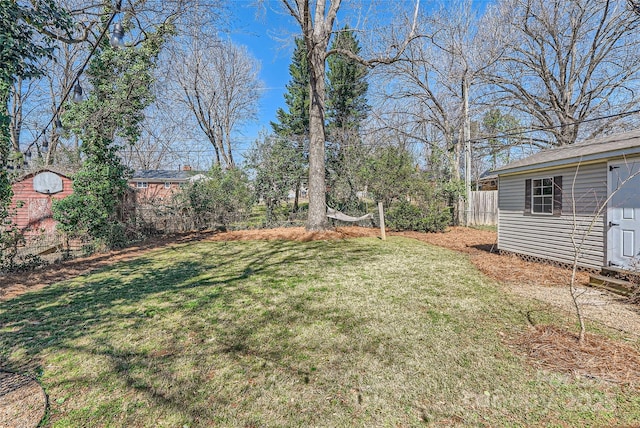 view of yard featuring an outdoor structure and fence