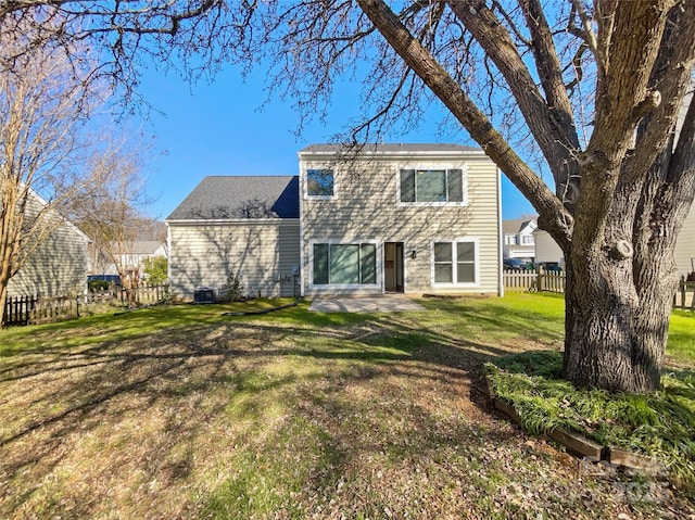 view of front of property with a lawn, central AC, and fence