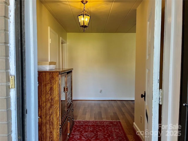 hall with baseboards and dark wood-style flooring