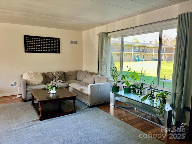 living room featuring visible vents and wood finished floors