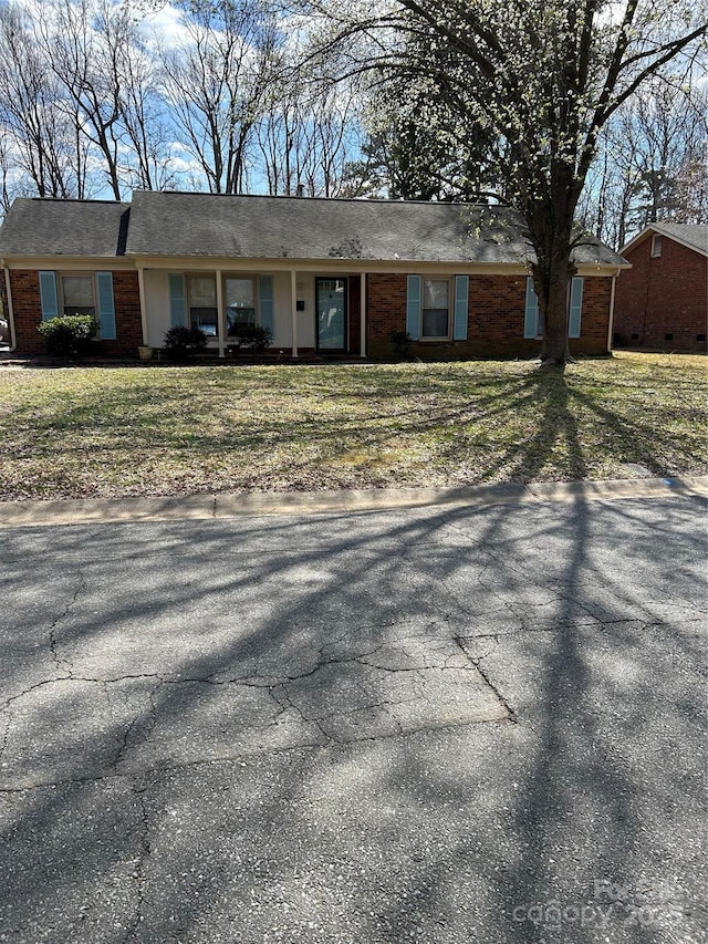 ranch-style house with a front yard and brick siding