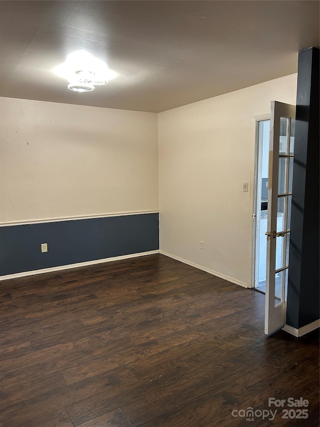 empty room with baseboards and dark wood-style floors