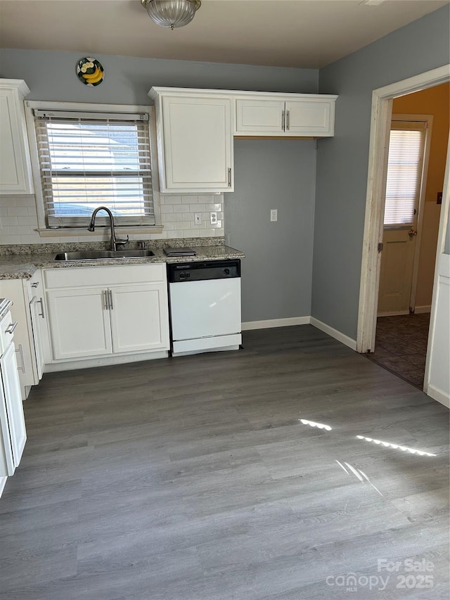 kitchen with a sink, wood finished floors, white cabinetry, decorative backsplash, and dishwasher